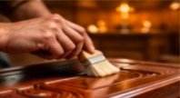 Polish being brushed onto a wooden door panel